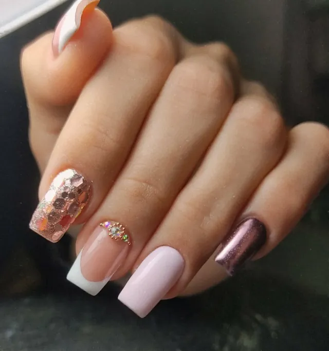 Uñas cuadradas en rosa palo combinadas con glitter oro rosa, pedrería y una uña de efecto espejo.